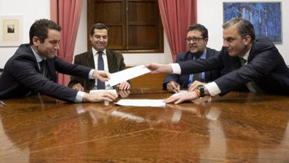 García Egea, secretario general del PP, y Ortega Smith, secretario general de Vox, intercambian los papeles del acuerdo. Al fondo, izquierda, el futuro presidente de la Junta, Moreno, del PP, con Serrano, de Vox.