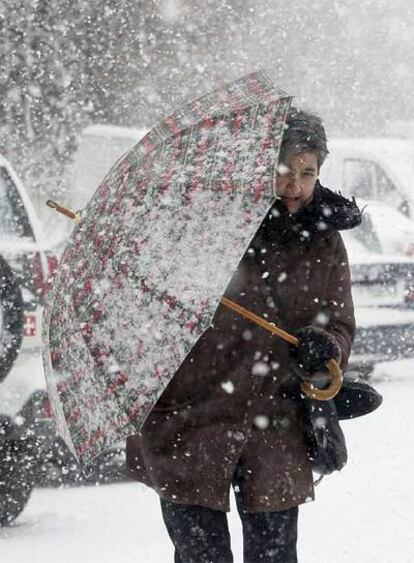 Una mujer se protege de la nieve, el sábado en Soria