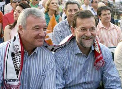 Rajoy y Ramón Luis Valcárcel, con una bufanda del Murcia, durante el mitin del PP ayer en esa ciudad.