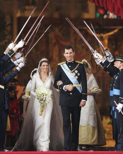 Felipe de Borbón y Leticia Ortiz pasan por el arco de sables de los compañeros de promoción del príncipe tras su boda en la catedral de la Almudena, de Madrid, el 22 de mayo de 2004.