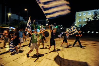 Hinchas griegos enarbolan banderas de su país frente al Parlamento de Atenas para celebrar la clasificación de su selección para los cuartos de la Eurocopa.