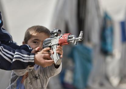 Un ni?o sirio kurdo de Kobane juega con un arma de juguete en el campamento de Suruc, en la frontera entre Turqua y Siria.