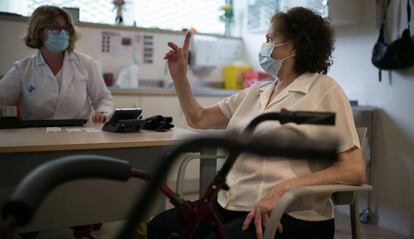 La doctora María Nualart at'en la wseva pacient Longina Villaverde en una consulta del centre d'atenció primària Casernes de Barcelona.