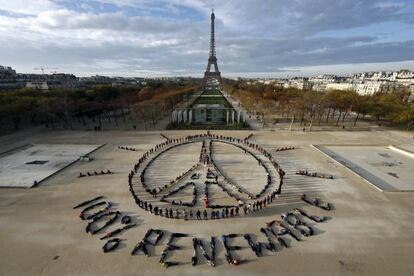 Cientos de activistas ecologistas se unen el domingo en Par&iacute;s para formar un mensaje que pide el 100% de las energ&iacute;as renovables.