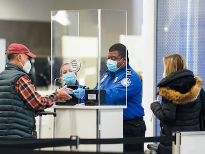 Un agente de la Administración de Seguridad en el Transporte atiende a un viajero en un puesto de control en un terminal del aeropuerto de LaGuardia, Nueva York.