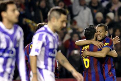 Xavi y Alves se abrazan ante los jugadores del Valladolid en el partido de la primera vuelta (0-3 en Zorrilla).