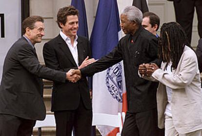 Nelson Mandela, junto a Whoopi Goldberg, saluda a Robert de Niro y a Hugh Grant.