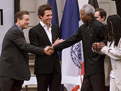 Nelson Mandela, junto a Whoopi Goldberg, saluda a Robert de Niro y a Hugh Grant.