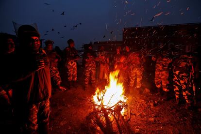 Soldados indios se calientan alrededor de una hoguera, en Srinagar (India). 