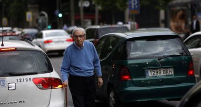 En un día laborable se producen más de 2,5 millones de desplazamientos en vehículo privado; siete de cada diez tienen su origen o destino en la periferia. En la imagen, un peatón sortea el tráfico en la calle Serrano.