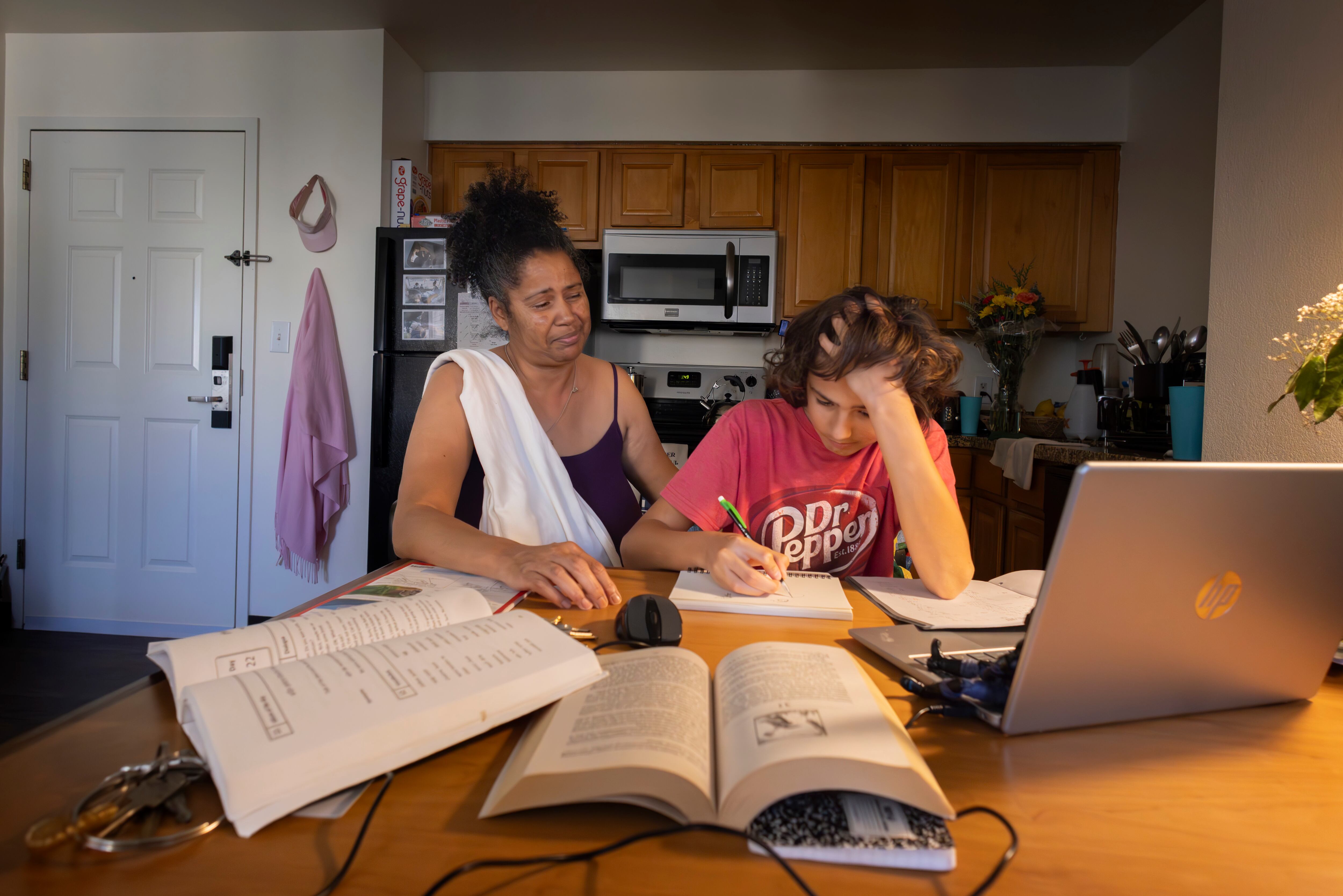 Ayden estudia con su madre en su nueva casa. 