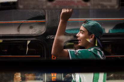 Barristas de Los Del Sur cantan por las ventanas de un bus durante un viaje para ir a ver a Nacional.