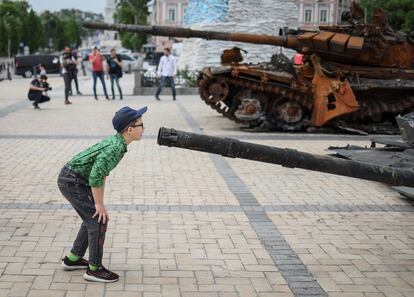 Un niño mira un vehículo ruso de infantería destrozado en una exhibición en el centro de Kiev, este sábado.