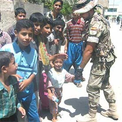 Un legionario español, junto a un grupo de niños en la localidad iraquí de Diwaniya.