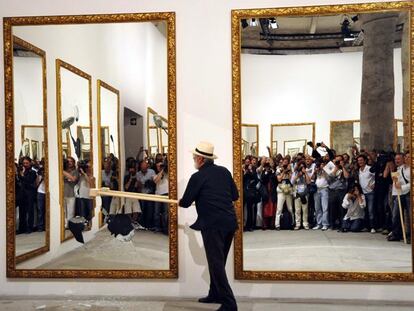 El artista Michelangelo Pistoletto rompe uno de los espejos de su instalación/<i>performance</i> en la Bienal de Venecia.