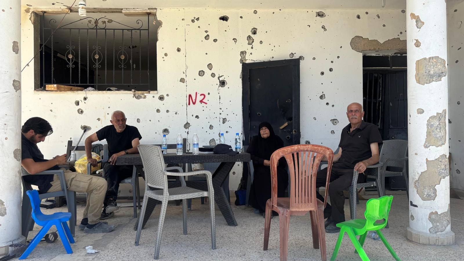 Hassan Ghazal (derecha) junto con miembros de su familia en la entrada de su vivienda, en Zawtar el Gharbiyeh.