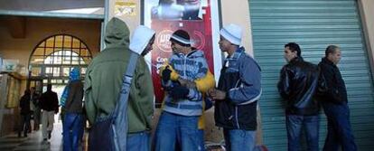 Un grupo de inmigrantes se cobijan del frío, el pasado sábado en la estación de autobuses de Jaén.