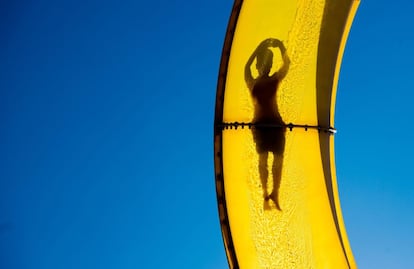 Un visitante de la piscina pública al aire libre "Suedbad" se desliza por uno de sus toboganes, en Hameln (Alemania).