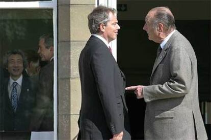 Blair y Chirac (en primer plano) conversan en Gleneagles, mientras Bush y Koizumi hacen lo mismo tras los cristales.