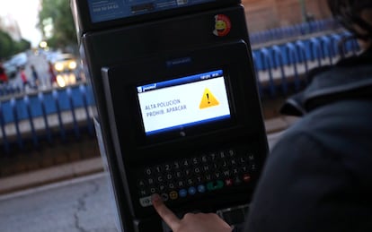 A Madrid parking meter with a warning sign that it is out of use.