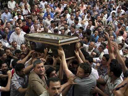 Cristianos coptos portan el féretro de uno de los fallecidos en los enfrentamientos con musulmanes en un suburbio de El Cairo.
/