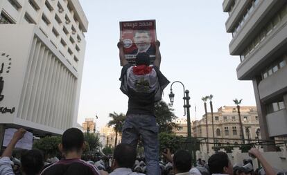 Un manifestante muestra durante la protesta a las puertas del Parlamento un cartel electoral de Mohamed Mosri, candidato de los Hermanos Musulmanes a la presidencia.