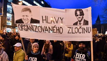 Dos manifestantes llevan una pancarta con la foto del primer ministro eslovaco, Robert Fico, y su ministro de Interior, Robert Kalinak, en una protesta en Bratislava.