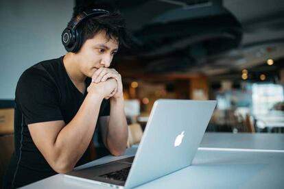 Chico escuchando música en un Mac