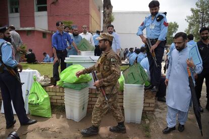 Soldados y policías vigilan los materiales electorales antes del reparto entre los distintos centros de votación en Islamabad (Pakistán).