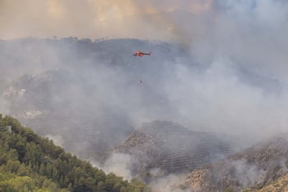 Un helicóptero en la zona del incendio, en la sierra de la Granadella, junto a una de las urbanizaciones cercanas a Benitatxell.