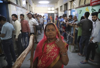 Una mujer muestra una marca indeleble en su dedo tras votar en Nueva Delhi, India el 12 de mayo de 2019.