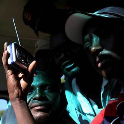 Un grupo de zimbabuenses escucha la radio en Harare a la espera de noticias sobre el resultado electoral.