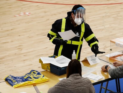 Un  cartero entrega el voto por correo en una mesa durante las elecciones catalanas del 14 de febrero.