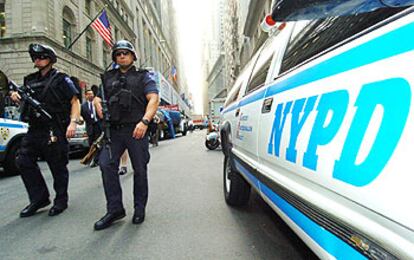 Policías neoyorquinos patrullan junto a la Bolsa de Wall Street, uno de los edificios en los que se ha elevado la alerta antiterrorista.