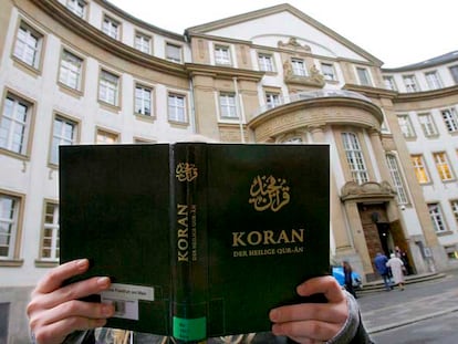Una mujer posa con un ejemplar del Corán frente a un juzgado de Francfort, en Alemania.