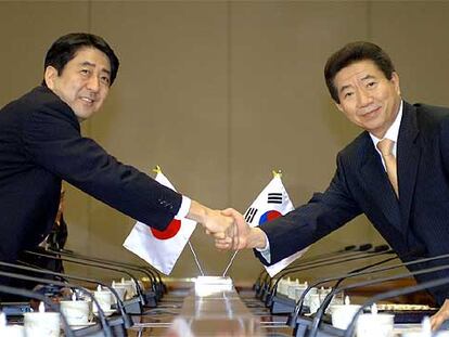El primer ministro japonés, Shinzo Abe (izquierda), estrecha la mano del presidente surcoreano, Roh Moo-hyun, ayer en Seúl.
