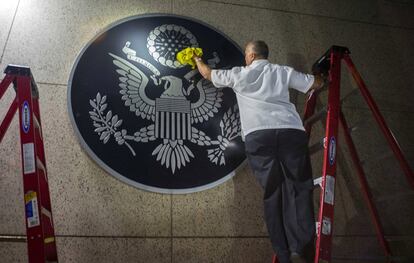 Un trabajador limpia una imagen de 'The Great Seal of the United States' en la embajada de EE UU en La Habana, Cuba.