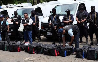 Miembros de la Polic&iacute;a vigilan veh&iacute;culos y equipos incautados.