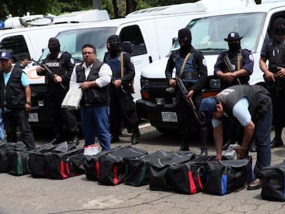 Miembros de la Policía vigilan vehículos y equipos incautados.