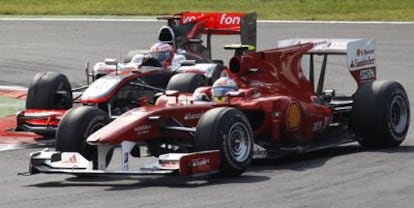 Fernando Alonso adelanta a Jenson Button durante el Gran Premio de Italia en el circuito de Monza.