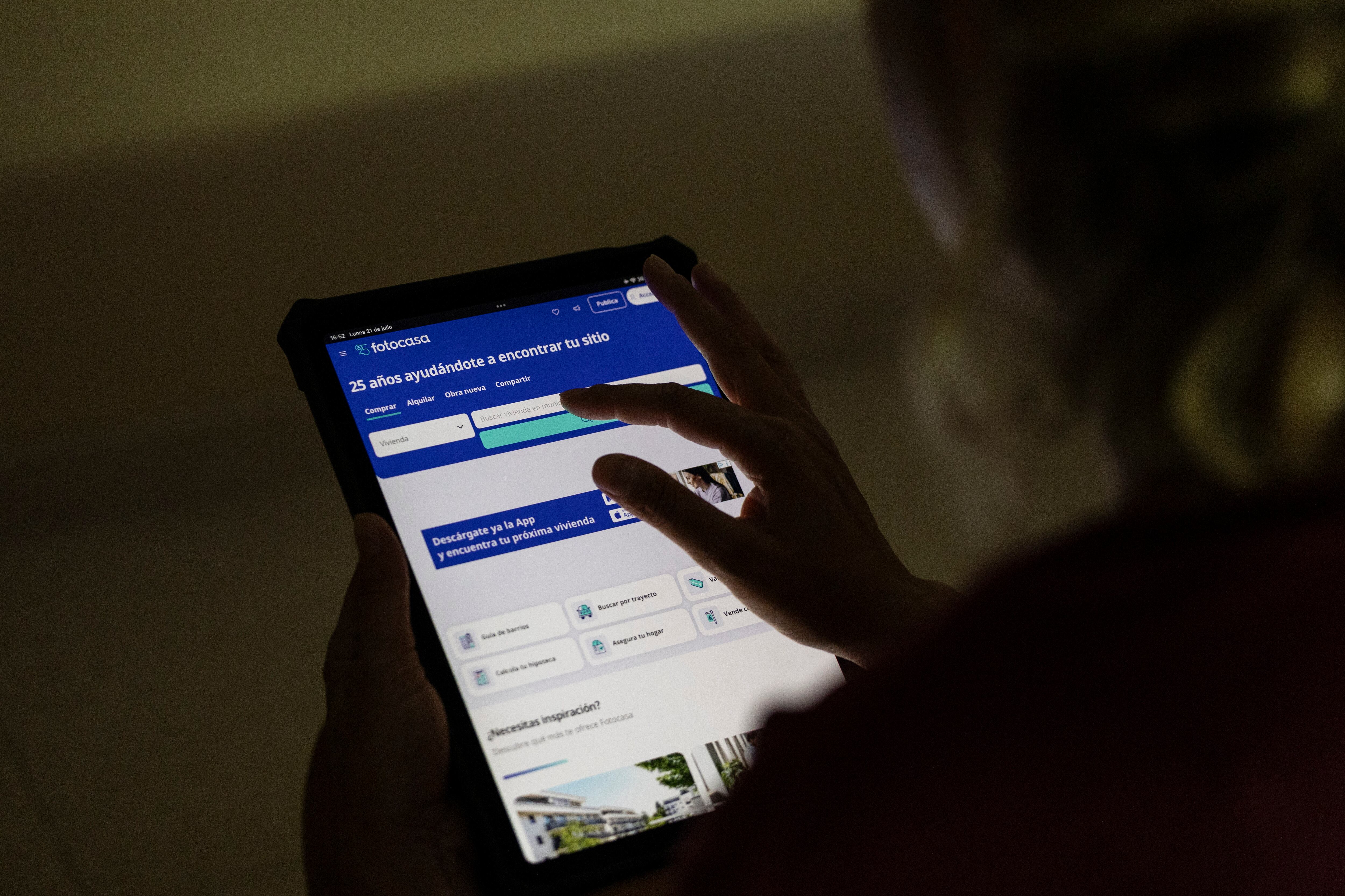 Una mujer consulta la pagina web de Fotocasa con un tablet.
