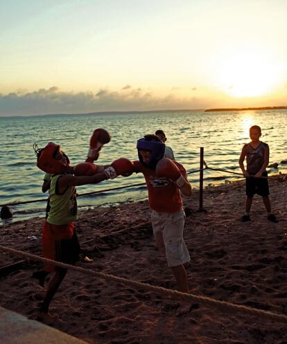 Durante el ocaso en una playa de Cienfuegos, un grupo de muchachos se ejercita en el boxeo.