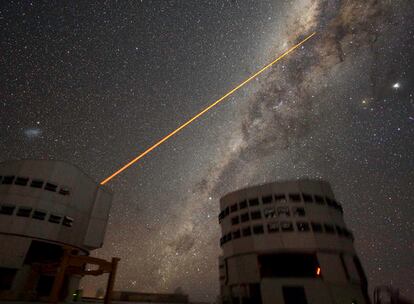 Imagen del cielo y dos cúpulas del Very Large Telescope del Observatorio Europeo Austral, en Cerro Paranal. La calidad del cielo para observaciones astronómicas en esta región de Chile es de las mejores del mundo debido la transparencia y estabilidad de la atmósfera. Algunos observatorios utilizan un láser para medir las variaciones en la atmósfera y, mediante pequeñas variaciones en la óptica del telescopio, compensarlas y aumentar la calidad de las imágenes. En este caso, el láser apunta al centro de la Vía Láctea, la galaxia donde vivimos.