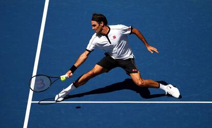 Federer devuelve la pelota durante el partido contra Evans.