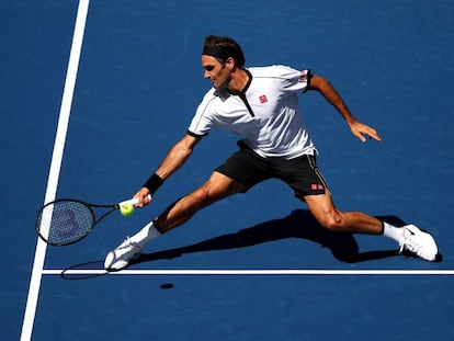Federer devuelve la pelota durante el partido contra Evans.