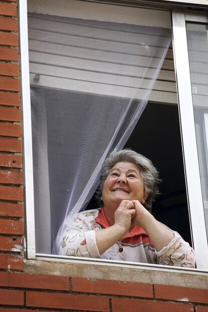 María Dolores se asoma a una ventana de su casa en Terrassa.