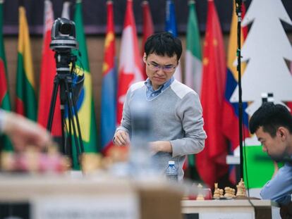 Yangyi Yu mira la posición de su partida con Liren Ding mientras pasea por la sala durante el turno de juego de su rival