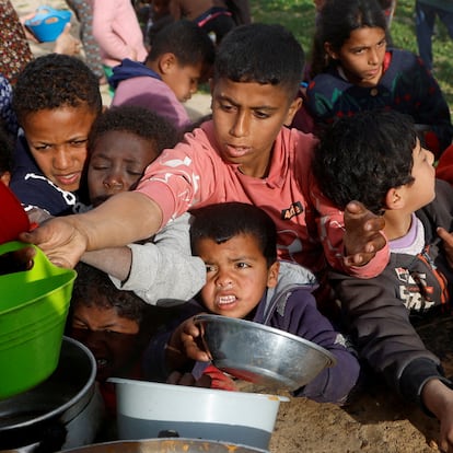 Palestinian children gather to receive food cooked by a charity kitchen, during the Muslim holy month of Ramadan, in Khan Younis, in the southern Gaza Strip, March 3, 2025. REUTERS/Hatem Khaled     TPX IMAGES OF THE DAY