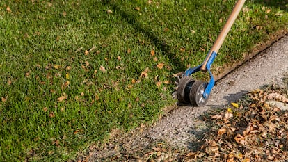 Cortador césped siendo utilizado en un jardín.