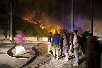 Un grupo de vecinos de Vallirana Park observan cómo el fuego se acerca a sus casas. 150 personas abandonaron ayer domingo sus viviendas.